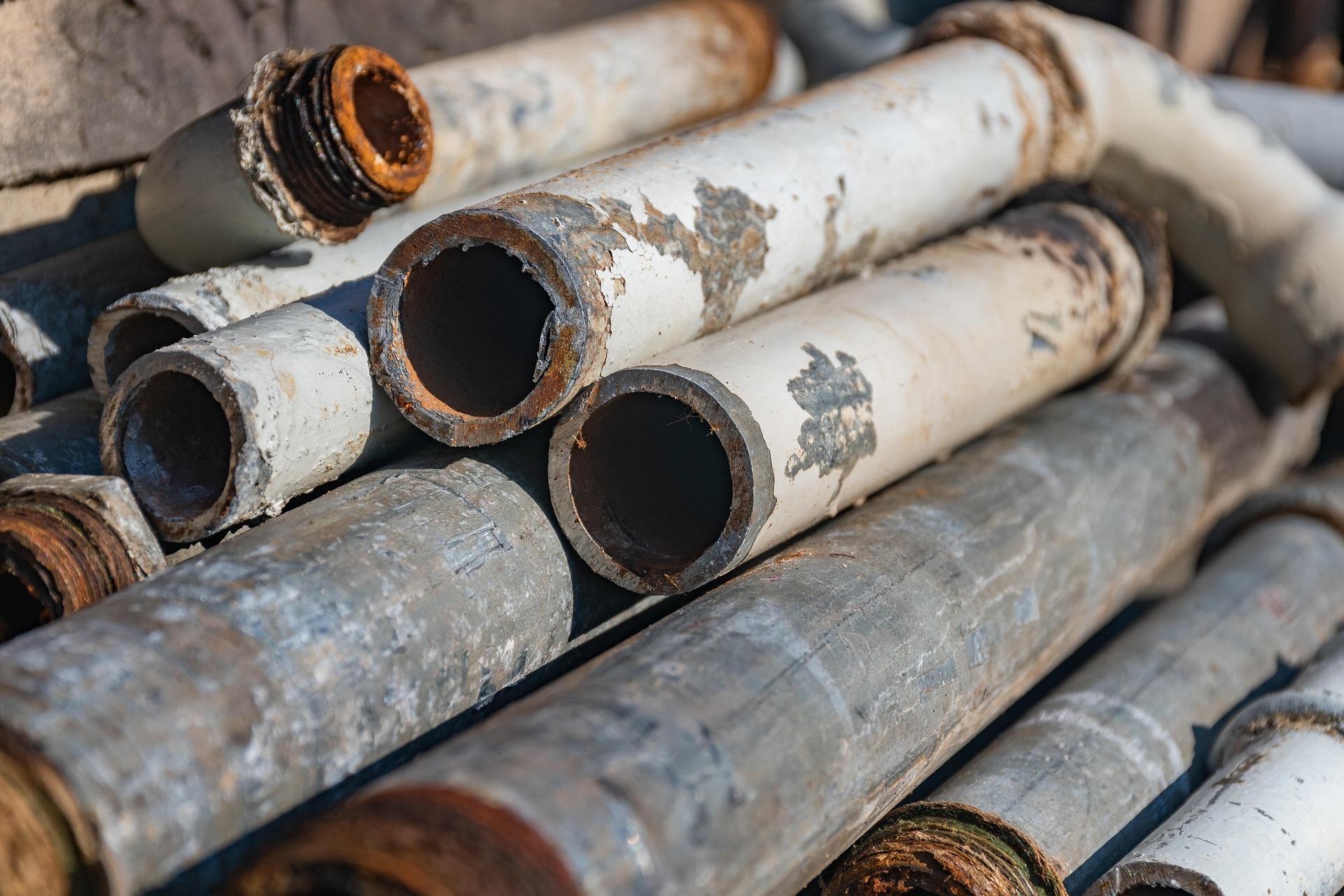 Worker inspecting stacked metal sheets